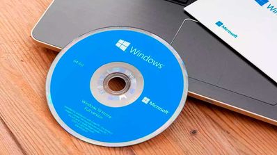 Caja y DVD de instalación de la versión física (retail) de Windows 10 sobre un fondo azul.