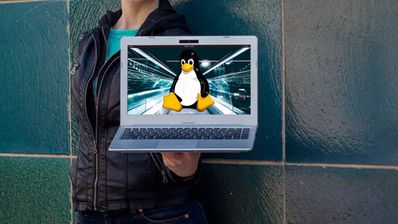 Un portátil antiguo de color plateado mostrando el escritorio de una distribución Linux ligera para demostrar cómo se puede revitalizar hardware obsoleto.