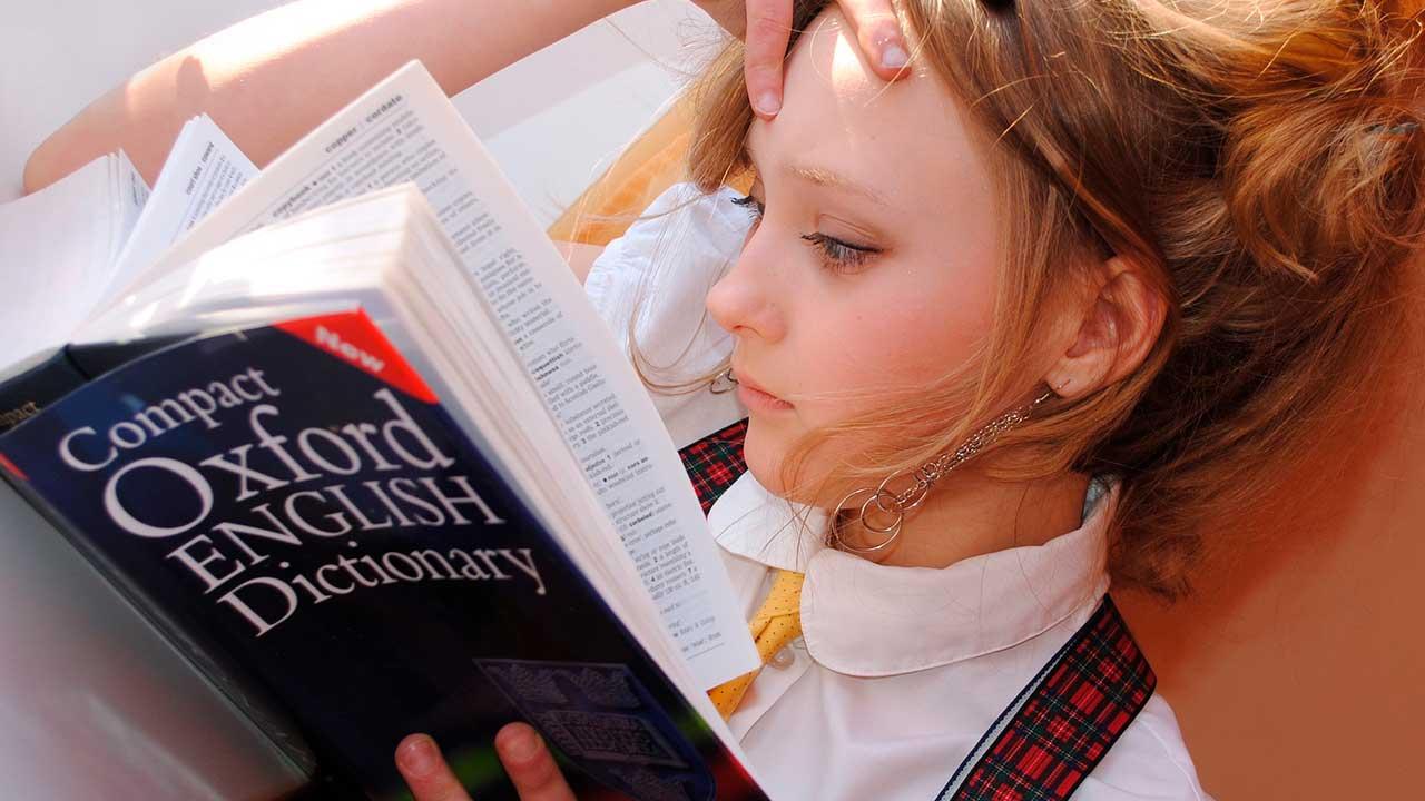 Chica leyendo diccionario de inglés