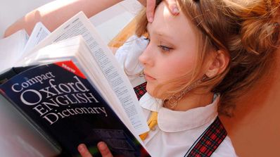 Chica leyendo diccionario de inglés