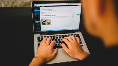 Persona escribiendo en un blog con un portátil