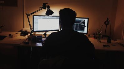 Persona trabajando con dos ordenadores