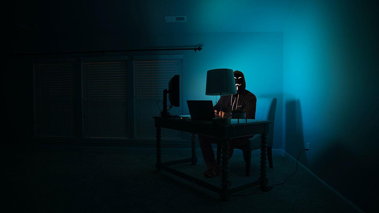 Hacker trabajando a oscuras en una habitación