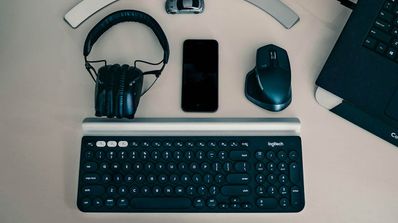 Ratón, teclado, auriculares y monitor sobre una mesa