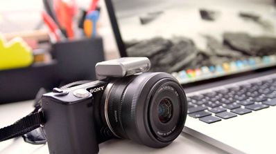 Cámara de fotos junto a un portátil