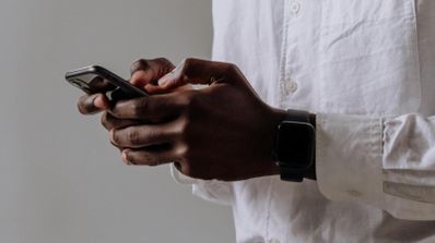 Una persona interactuando con la interfaz de la inteligencia artificial de Microsoft Copilot dentro de un chat de WhatsApp en su smartphone.