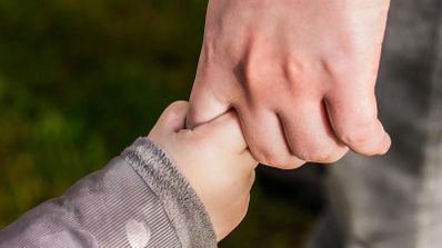 Hijo cogiendo de la mano a su padre