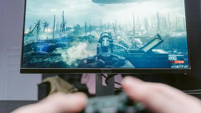 Jugador concentrado frente a un monitor de PC para gaming con un juego de disparos en pantalla, ilustrando el entorno ideal para usar VRR.