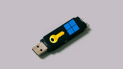 Memoria USB junto a una representación de una clave de producto, ilustrando el proceso de instalación de Windows