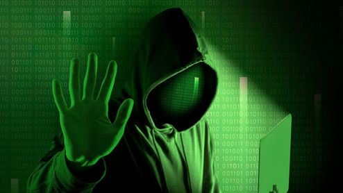 Hacker con un PC en primer plano.