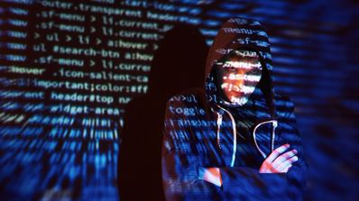 hacker junto a varias líneas de código fuente.