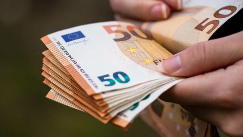 Montón de billetes de 50 euros en unas manos.
