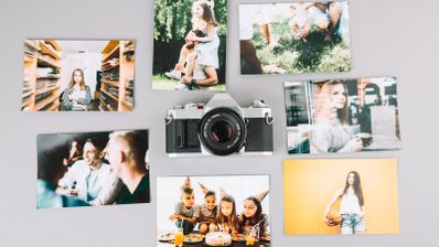 cámara de fotos rodeada de una serie de fotografías en papel.