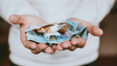 Fajo de billetes de euro ofrecido por una persona.