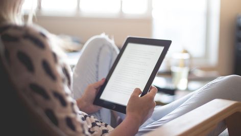Lector físico de ebooks en las manos de una mujer.