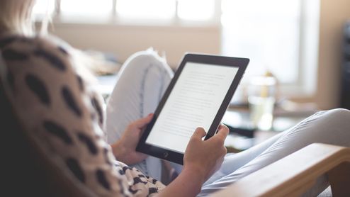 Lector físico de ebooks en las manos de una mujer.