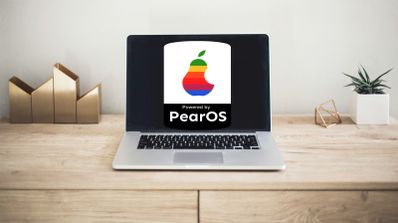 Portátil MacBook con pantalla mostrando el logo de PearOS, instalado en el dispositivo.