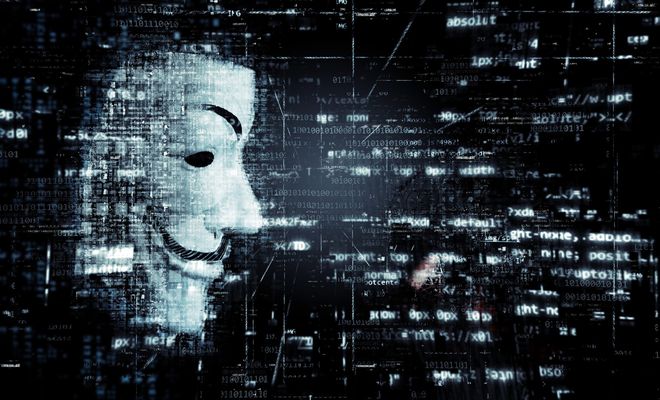 Rostro de un hacker rodeado de código fuente.