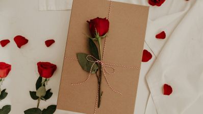 Tarjeta San Valentín cerrada con una rosa encima.