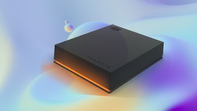 Disco duro externo Seagate de color negro con iluminación naranja en la base sobre un fondo abstracto en tonos azules y púrpuras.