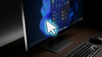 Monitor de ordenador mostrando el cursor del ratón resaltado con un brillo cian sobre la interfaz de Windows 11.