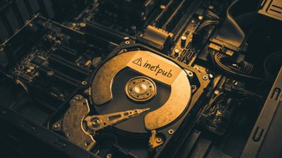 Primer plano de un disco duro abierto dentro de un ordenador con una etiqueta de advertencia que reza inetpub.