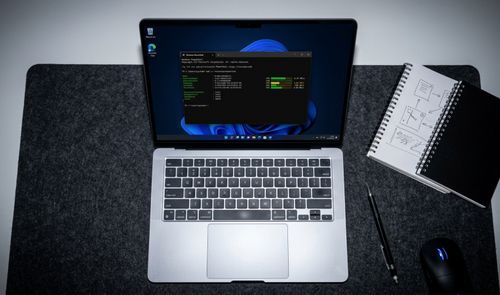 Ordenador portátil abierto mostrando una ventana de terminal con comandos sobre el escritorio de Windows 11.