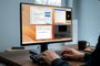 Persona utilizando un ordenador con Windows 11 y varias ventanas de aplicaciones abiertas simultáneamente en el monitor.