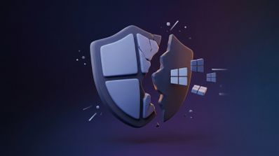Representación tridimensional de un escudo con el logotipo de Windows roto por la mitad sobre un fondo oscuro.