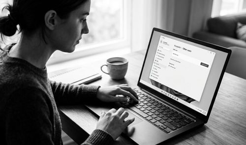 Persona utilizando un ordenador portátil que muestra el menú de configuración de cuentas de usuario en Windows 11.