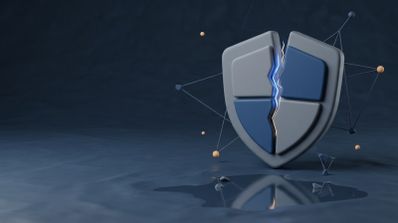 Ilustración en 3D de un escudo de seguridad gris y azul partido por la mitad con una grieta luminosa sobre un fondo oscuro.