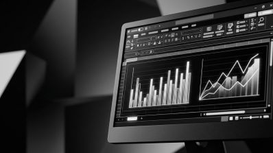 Monitor de ordenador en blanco y negro mostrando una interfaz de software de hojas de cálculo con gráficos de barras y de líneas.