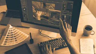 Persona editando una imagen en un ordenador con software de diseño gráfico profesional.