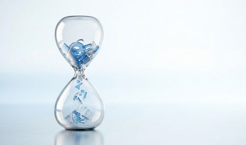 Reloj de arena con el logotipo de Internet Explorer desintegrándose al caer en la parte inferior sobre un fondo claro.
