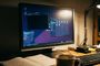 Monitor de escritorio mostrando la interfaz de usuario de MX Linux con varias ventanas abiertas sobre un escritorio de madera.