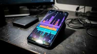 Interfaz de Adobe Premiere para Android en la pantalla de un smartphone mostrando una línea de tiempo con varias pistas de vídeo y audio en colores.