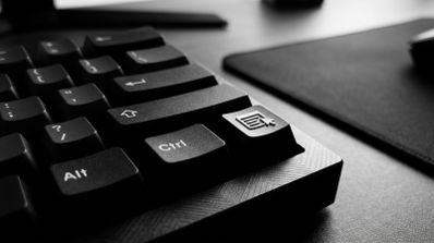 Primer plano de un teclado mecánico en blanco y negro mostrando las teclas Alt, Control y la tecla de menú contextual.