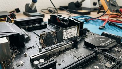 Unidad SSD NVMe M.2 instalada en la ranura de una placa base MSI B550 TOMAHAWK sobre un banco de trabajo.