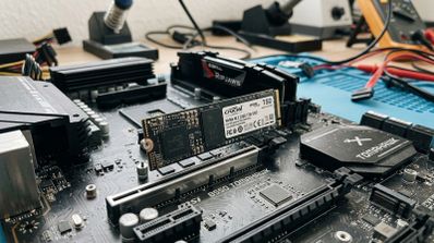 Unidad SSD NVMe M.2 instalada en la ranura de una placa base MSI B550 TOMAHAWK sobre un banco de trabajo.