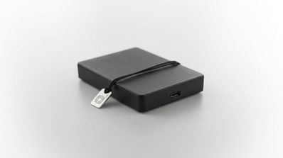 Unidad de disco duro externo Seagate Portable Drive de color negro con una placa metálica pequeña.