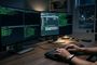 Manos de una persona escribiendo en un teclado ante dos monitores que muestran terminales de líneas de comandos con letras verdes e interfaces de gestión de archivos por SFTP.