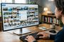 Persona frente a un monitor de ordenador que muestra una galería de fotos en Windows con un menú emergente para elegir la aplicación predeterminada.