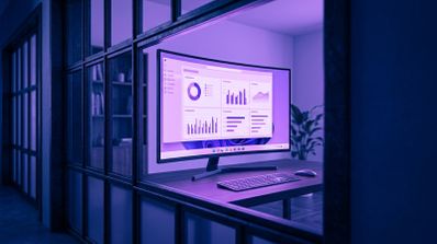 Monitor curvo sobre un escritorio con la interfaz de Windows 11 mostrando un panel de gráficos estadísticos en pantalla completa.