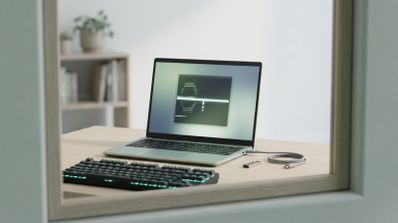 Ordenador portátil ejecutando una consola de comandos de Arch Linux sobre una mesa de madera junto a un teclado mecánico y una memoria USB.