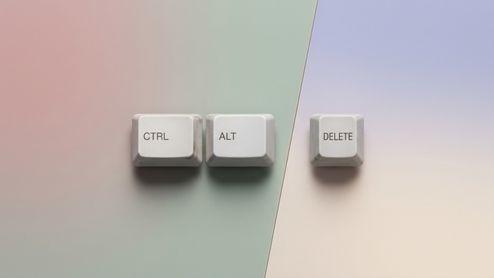 Tres teclas blancas de un teclado clásico con las etiquetas CTRL, ALT y DELETE dispuestas horizontalmente sobre un fondo de tonos pastel.