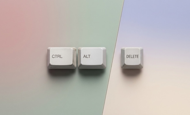 Tres teclas blancas de un teclado clásico con las etiquetas CTRL, ALT y DELETE dispuestas horizontalmente sobre un fondo de tonos pastel.