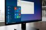 Monitor de ordenador mostrando el escritorio con el menú Inicio clásico de baldosas y una ventana del Explorador de archivos abierta sobre un fondo degradado azul y violeta.