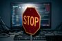 Señal de tráfico de stop frente a un monitor de ordenador que muestra un escritorio de Linux con varias ventanas abiertas.