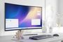 Monitor curvo que muestra el escritorio de KDE Plasma con ventanas abiertas junto al logotipo de KDE en una mesa de trabajo.
