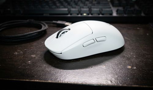 Ratón inalámbrico Logitech G Pro X Superlight 2 SE en color blanco sobre un escritorio oscuro junto a su cable de carga.